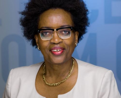 Dr. Petra Roberts smiling in front of a blue backdrop.